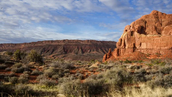 Formazioni rocciose rosse sotto cielo blu, palette cromatica ispirata alla natura