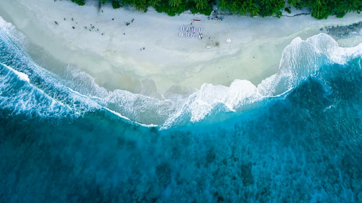 Vista aerea di spiaggia tropicale con acque turchesi, palette cromatica calma