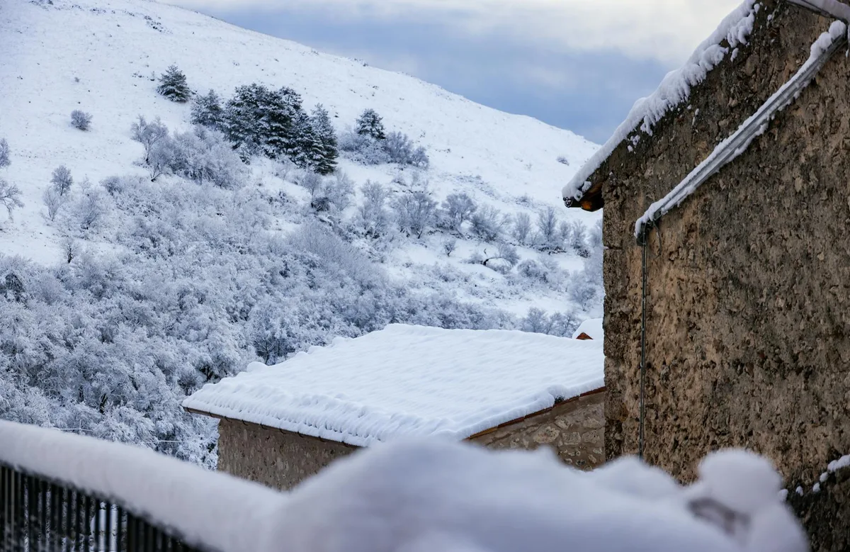 눈 덮인 시골 마을과 소박한 석조 주택의 그림 같은 겨울 풍경
