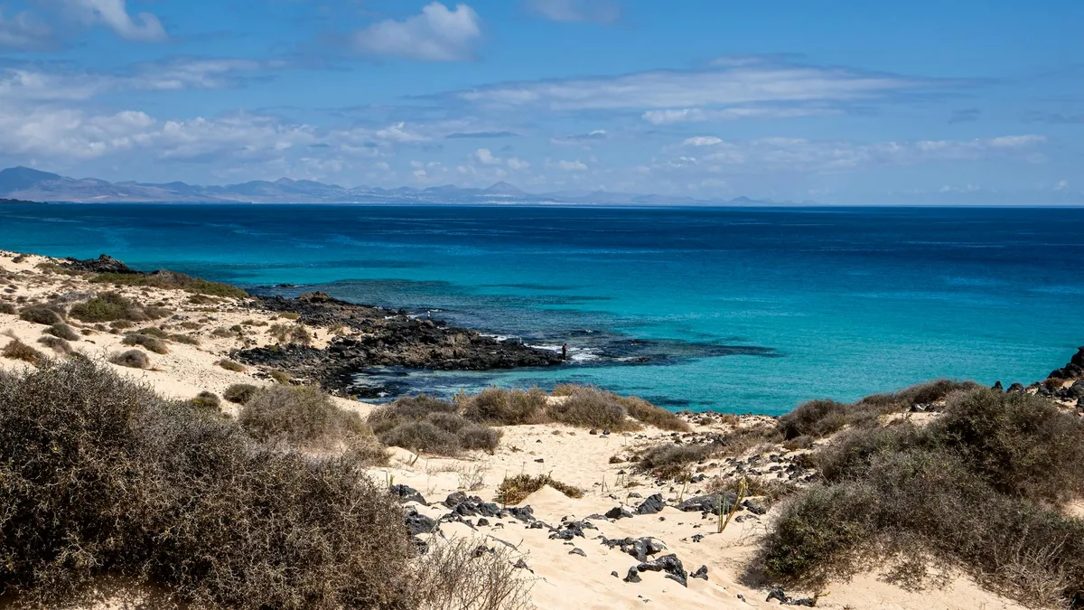 Türkisfarbenes Wasser und felsige Küste – perfekt für Sommerreise-Inspiration