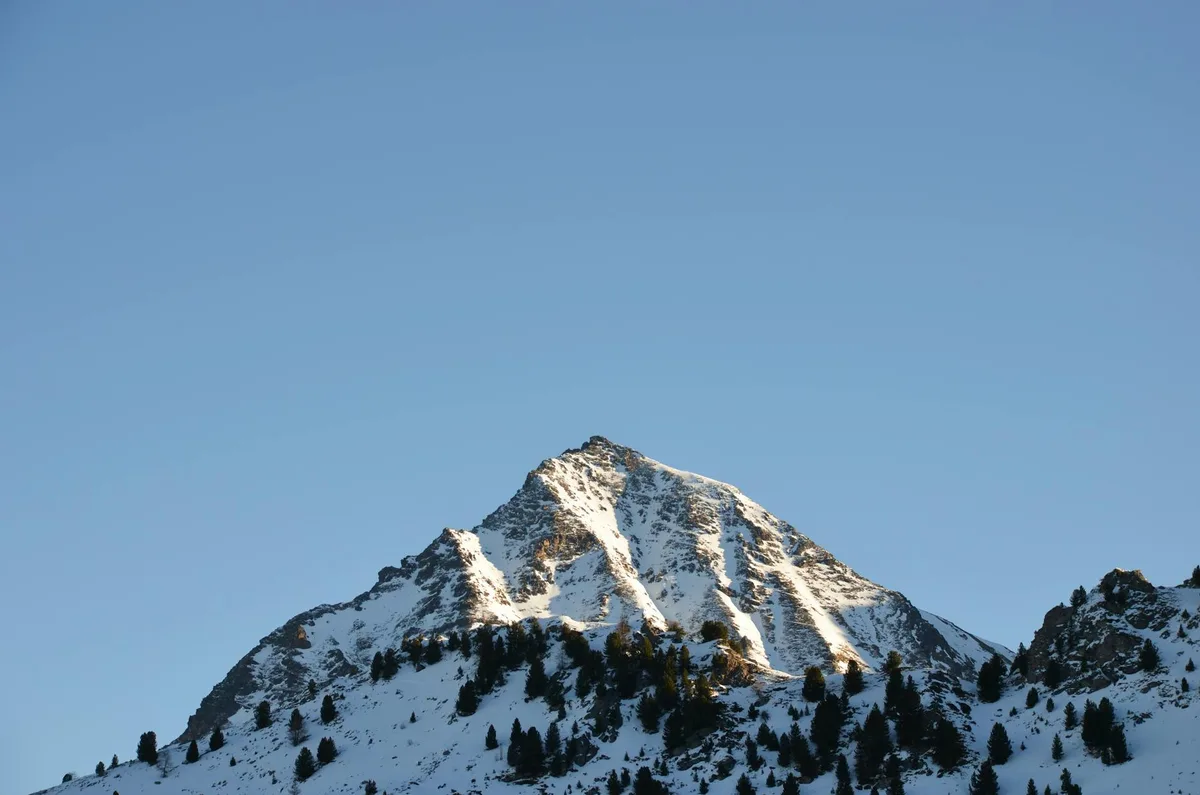 Vetta montuosa innevata contro cielo azzurro in Valle d'Aosta, Italia.