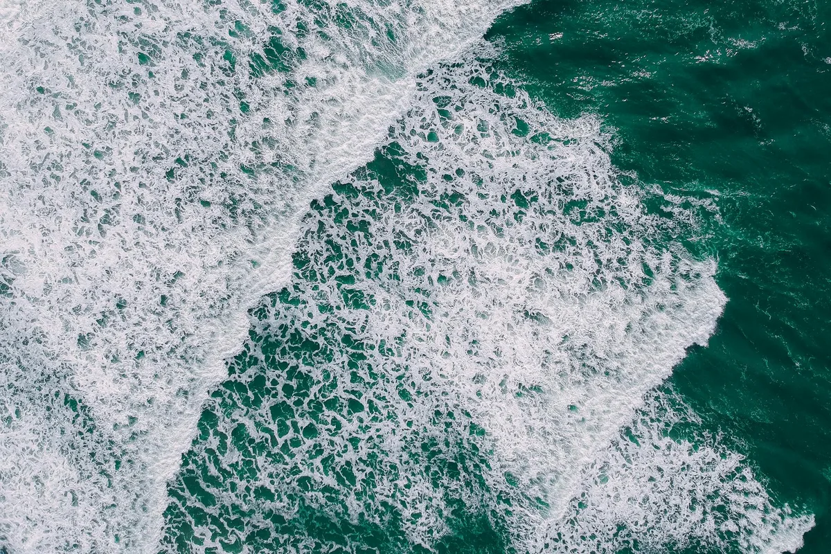 Ripresa aerea di onde oceaniche con motivi di schiuma intricati