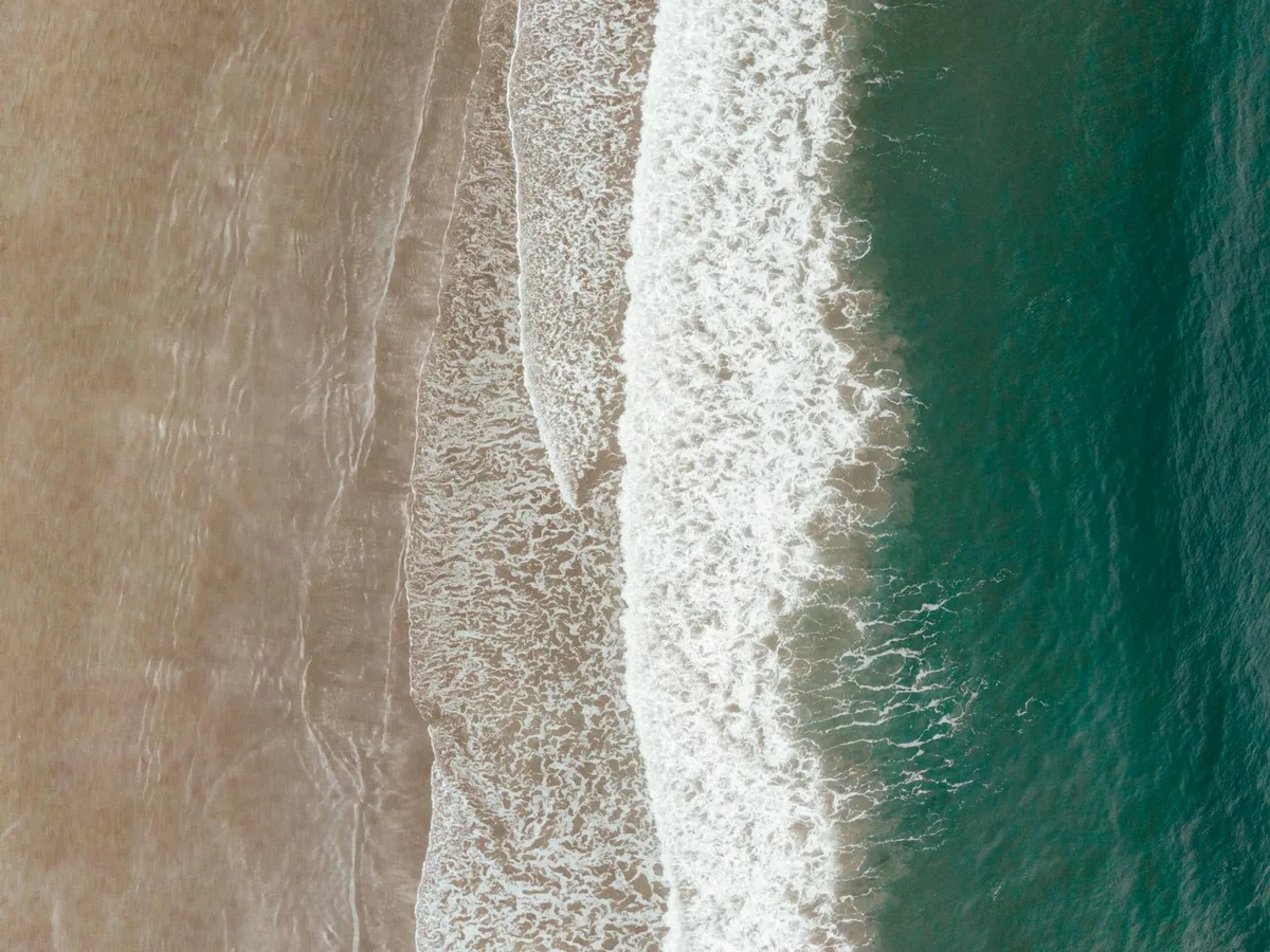 Luftaufnahme von Wellen, die an einem Sandstrand in Tofino, BC, Kanada brechen