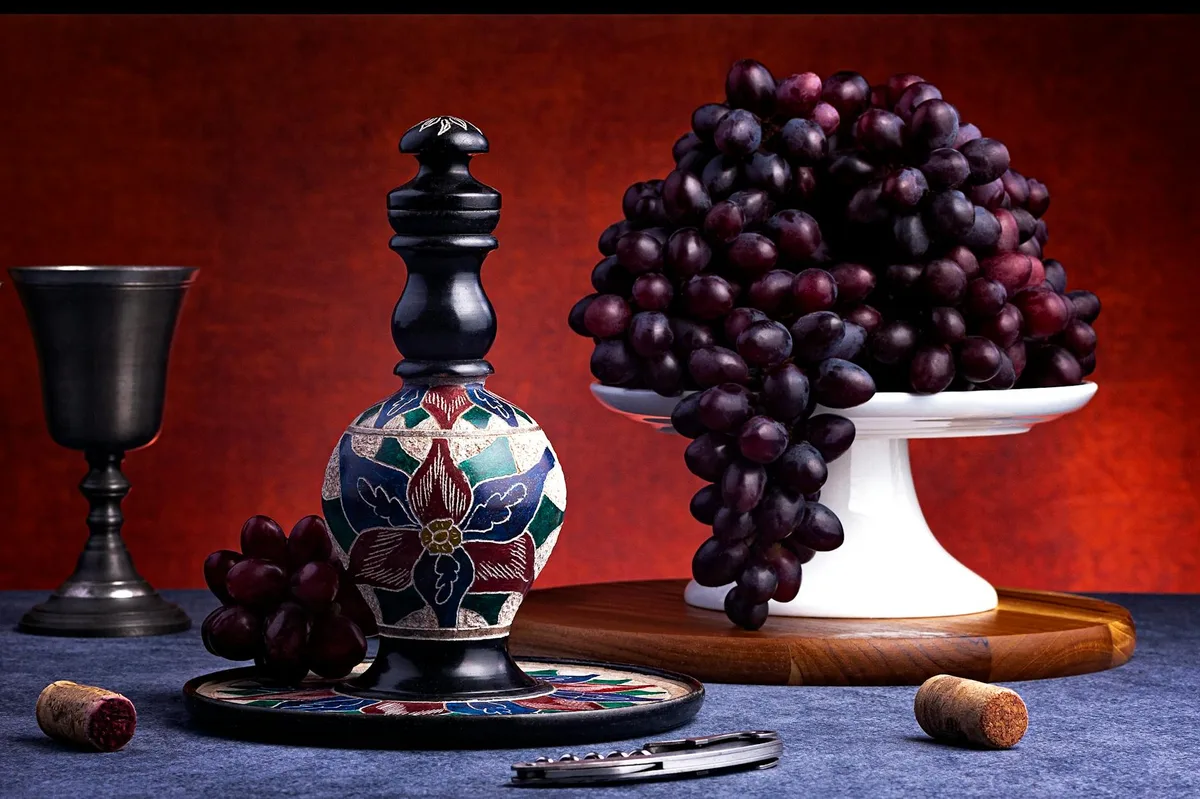 Nature morte sophistiquée avec raisins, bouteille et accessoires vin