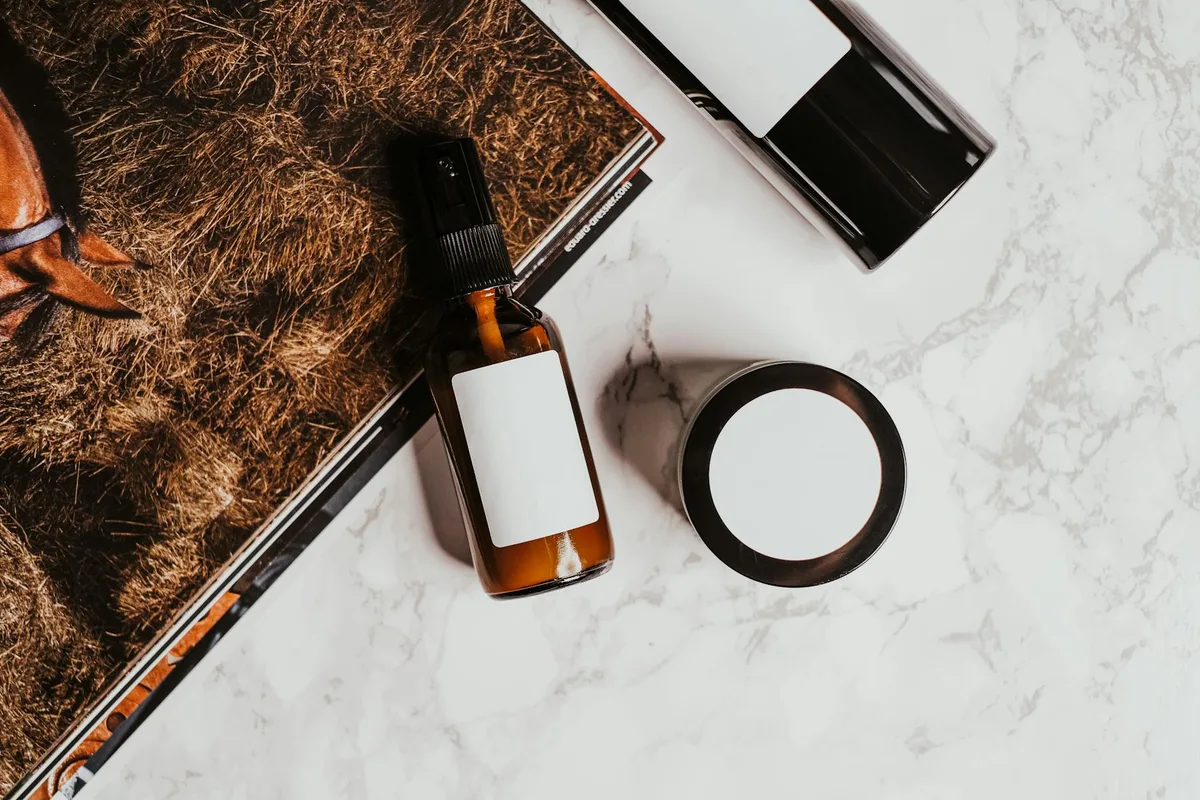 Flatlay elegante di prodotti skincare con rivista su superficie marmorea