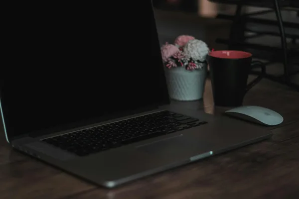 Spazio di lavoro indoor accogliente con laptop, tazza da caffè e decorazioni per lavoro da remoto