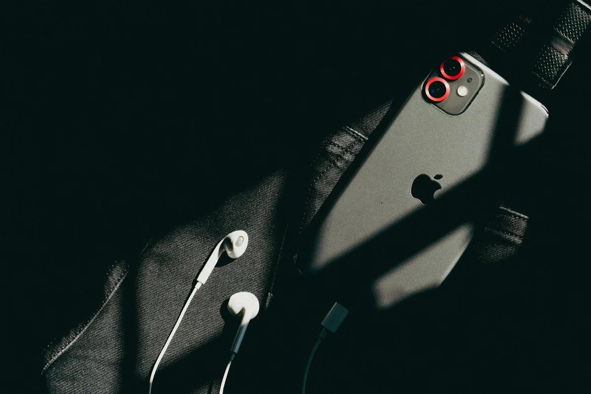 블랙 패브릭 위 미니멀 스마트폰과 이어버드, 세련된 디자인