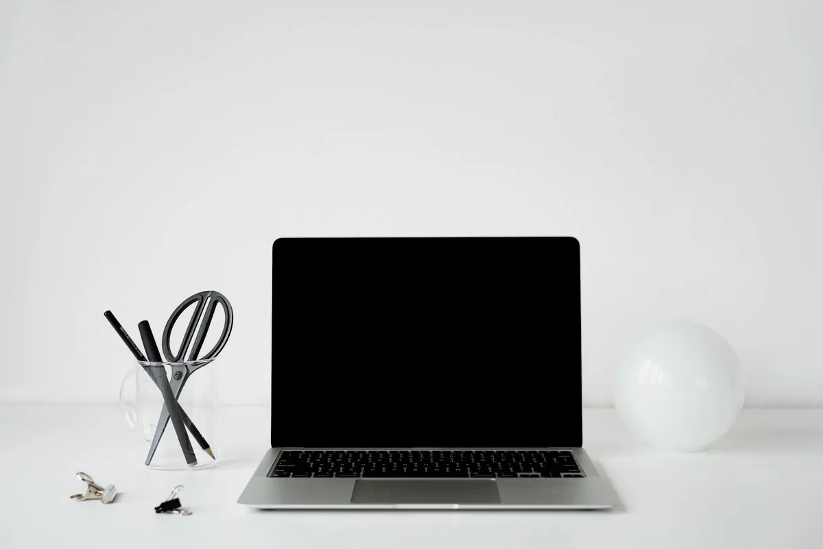 Ufficio moderno minimalista con laptop e decorazioni bianche su scrivania