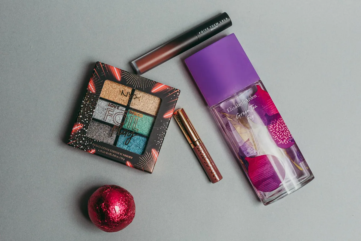 컬러 팔레트, 향수, 립스틱이 있는 세련된 플랫레이