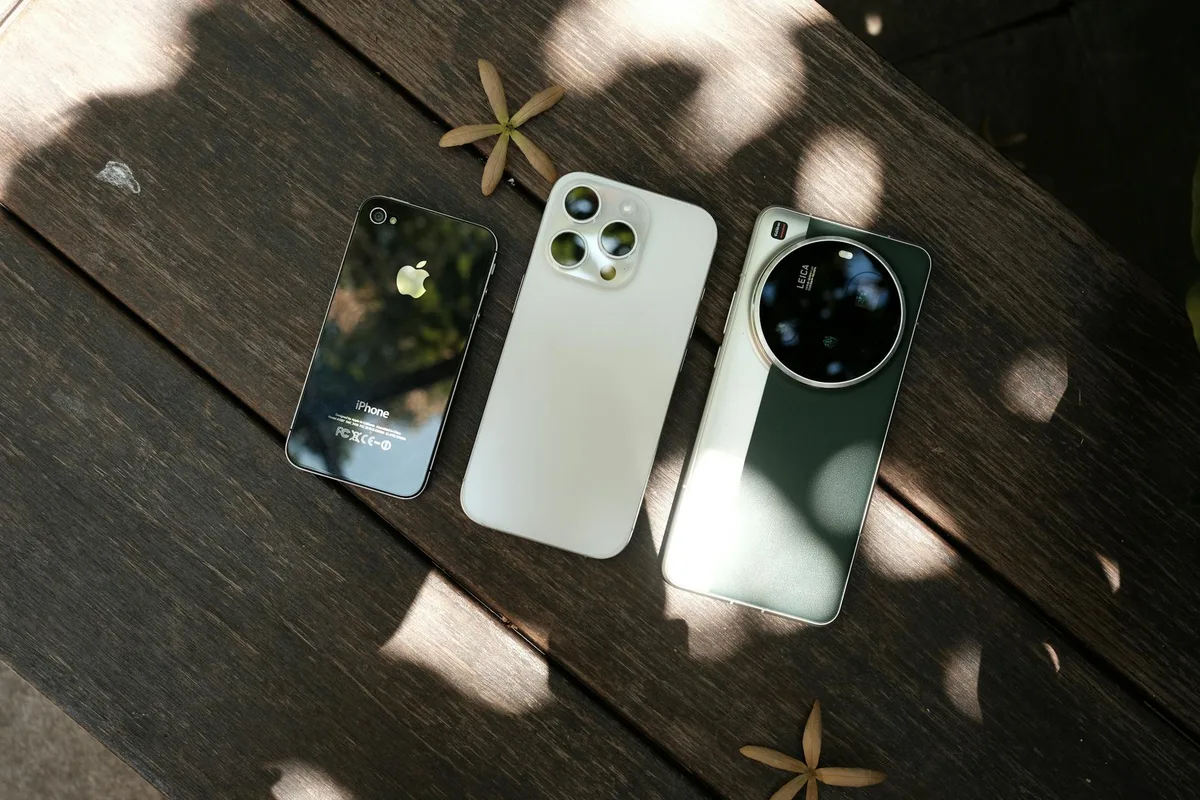 Три современных смартфона на деревянной поверхности при естественном освещении