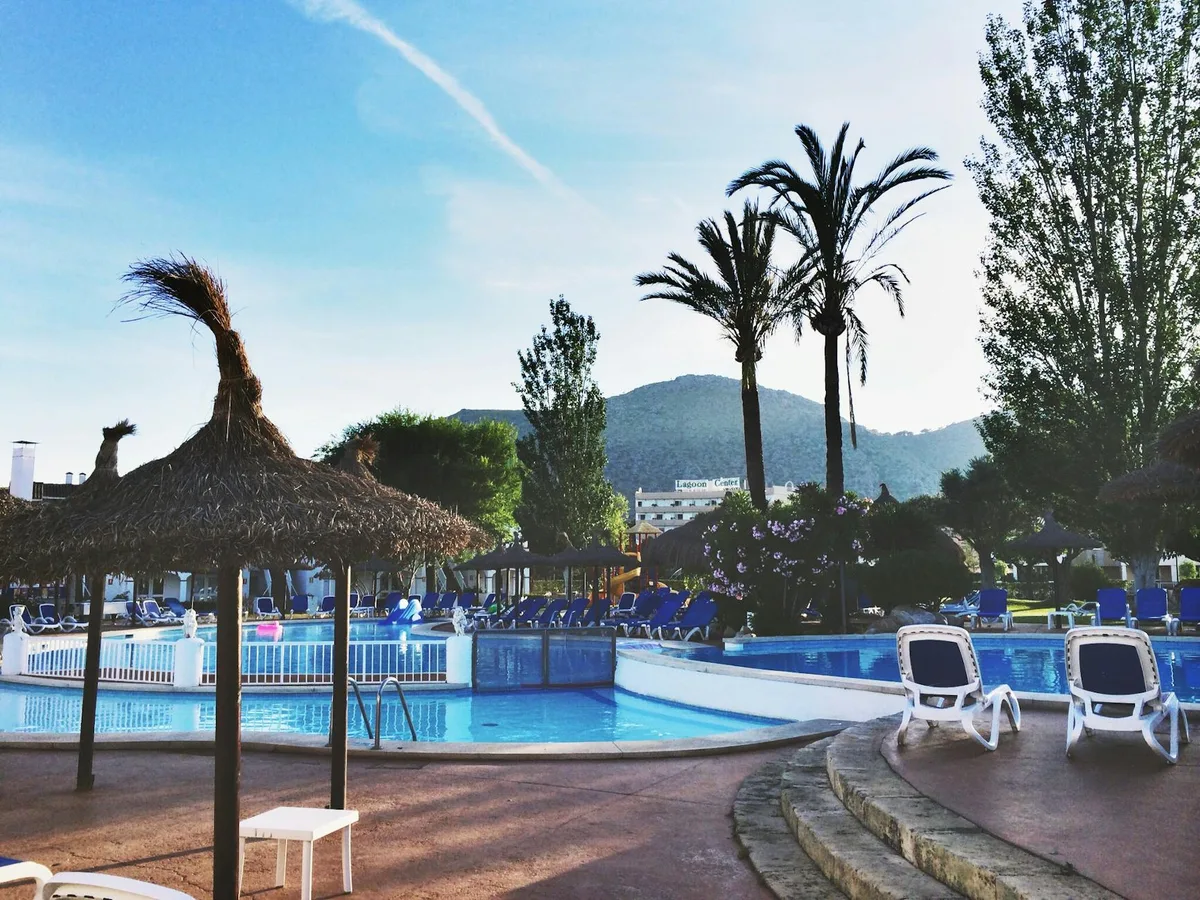 Ruhiger tropischer Resort-Pool mit Palmen und Sonnenliegen für Urlaubsstimmung