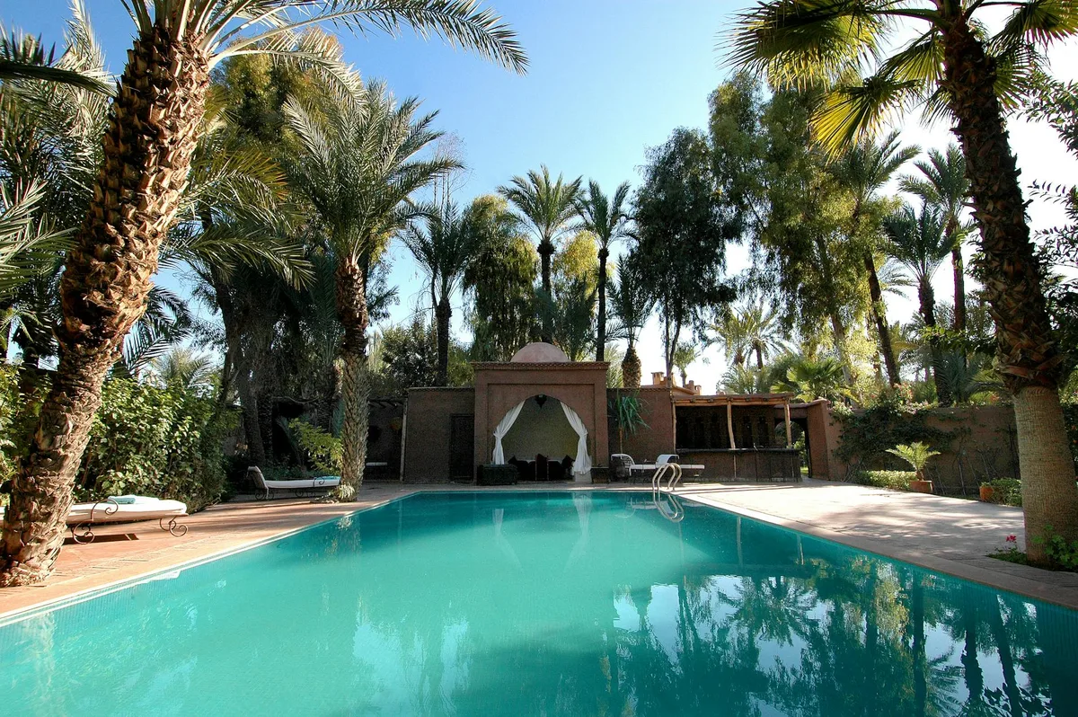 Atemberaubender tropischer Resort-Pool, umgeben von üppigen Palmen, perfekt für einen Sommerurlaub.