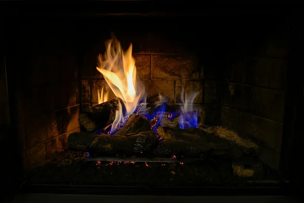 A warm, inviting fire burning in an indoor fireplace, perfect for cozy winter nights.