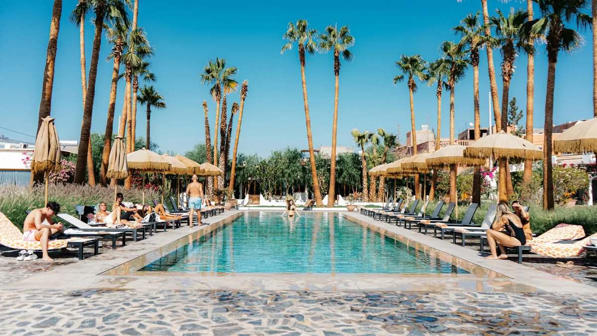 ヤシの木とプールサイドでくつろぐ人々のリゾート風景