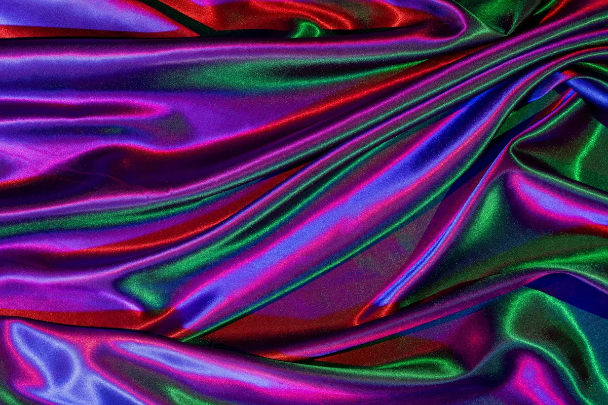 Primo piano di tessuto satinato vibrante e colorato con texture lucida e increspata per un design artistico.