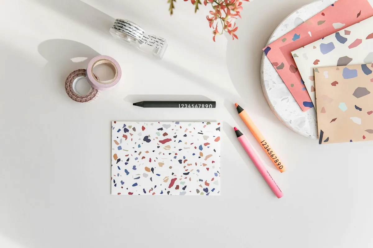 책상 위 테라조 노트북, 컬러풀 연필, 와시 테이프의 에어리얼 뷰