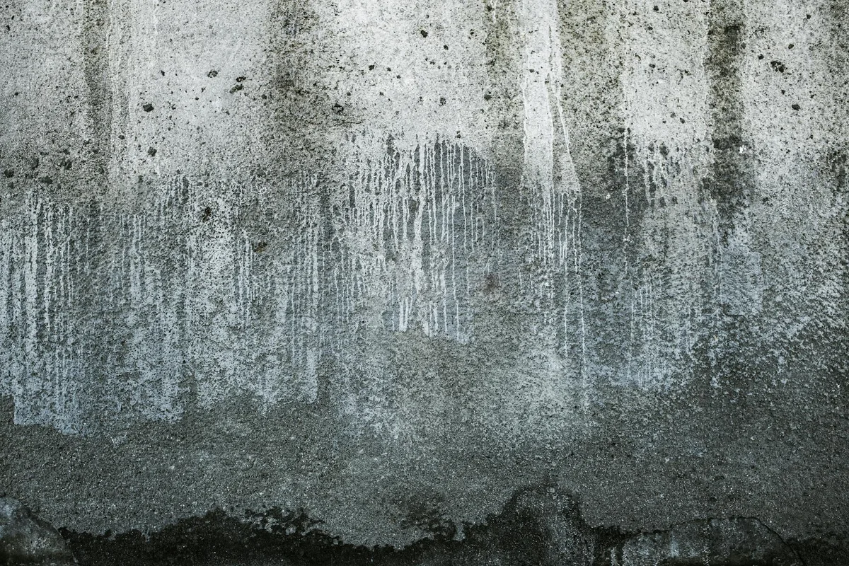 Primo piano muro cemento testurizzato con pattern stagionati e colature