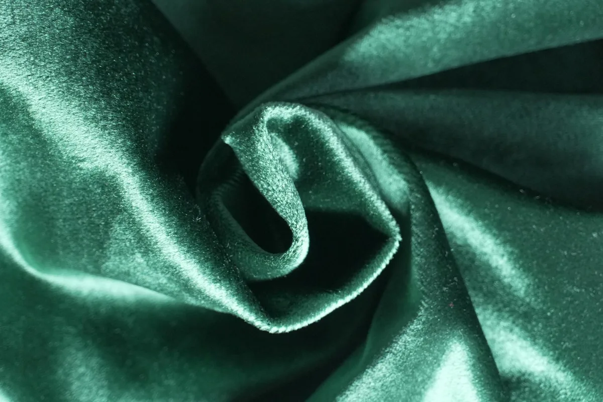 Primo piano di velluto verde smeraldo con lucentezza lussuosa e texture