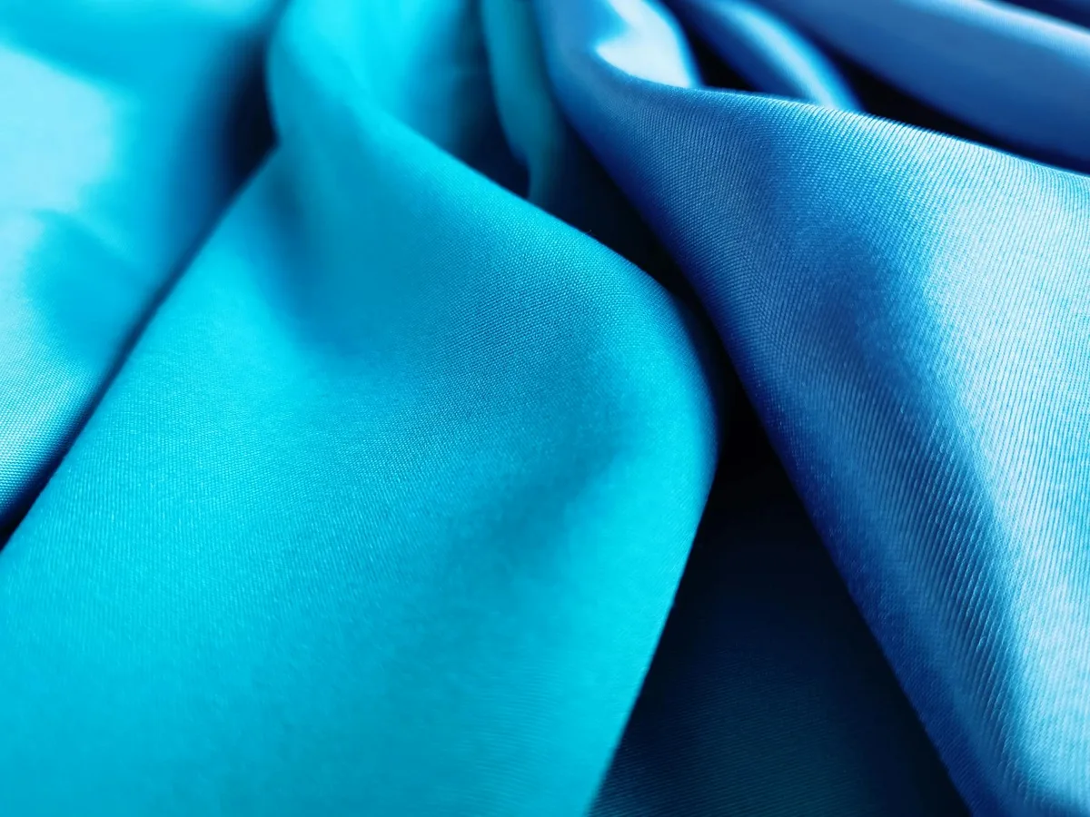 Primo piano di seta blu vivida con pieghe eleganti e texture raffinata
