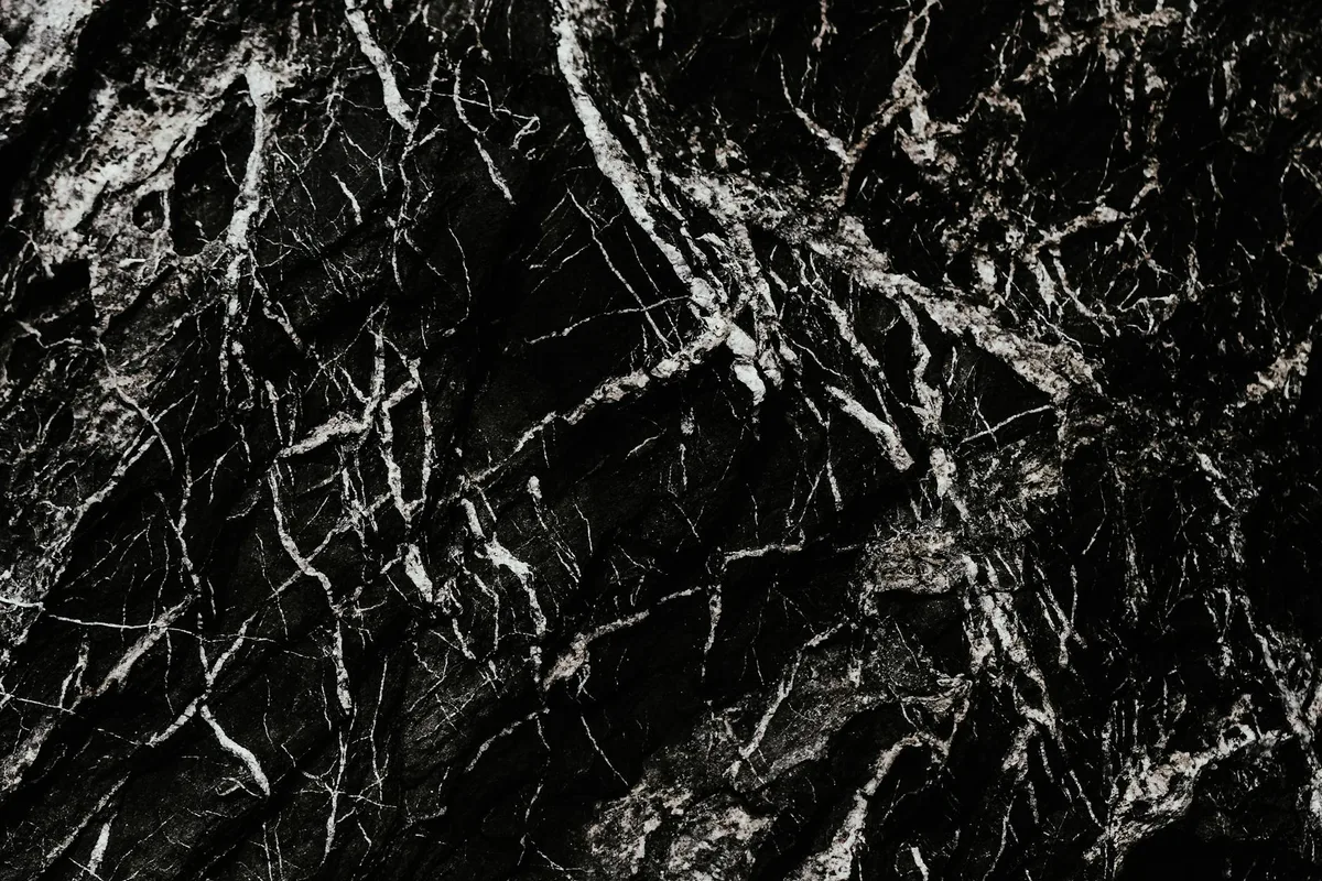 Nahaufnahme einer schwarzen Marmoroberfläche mit weißen Adern als abstraktes Muster