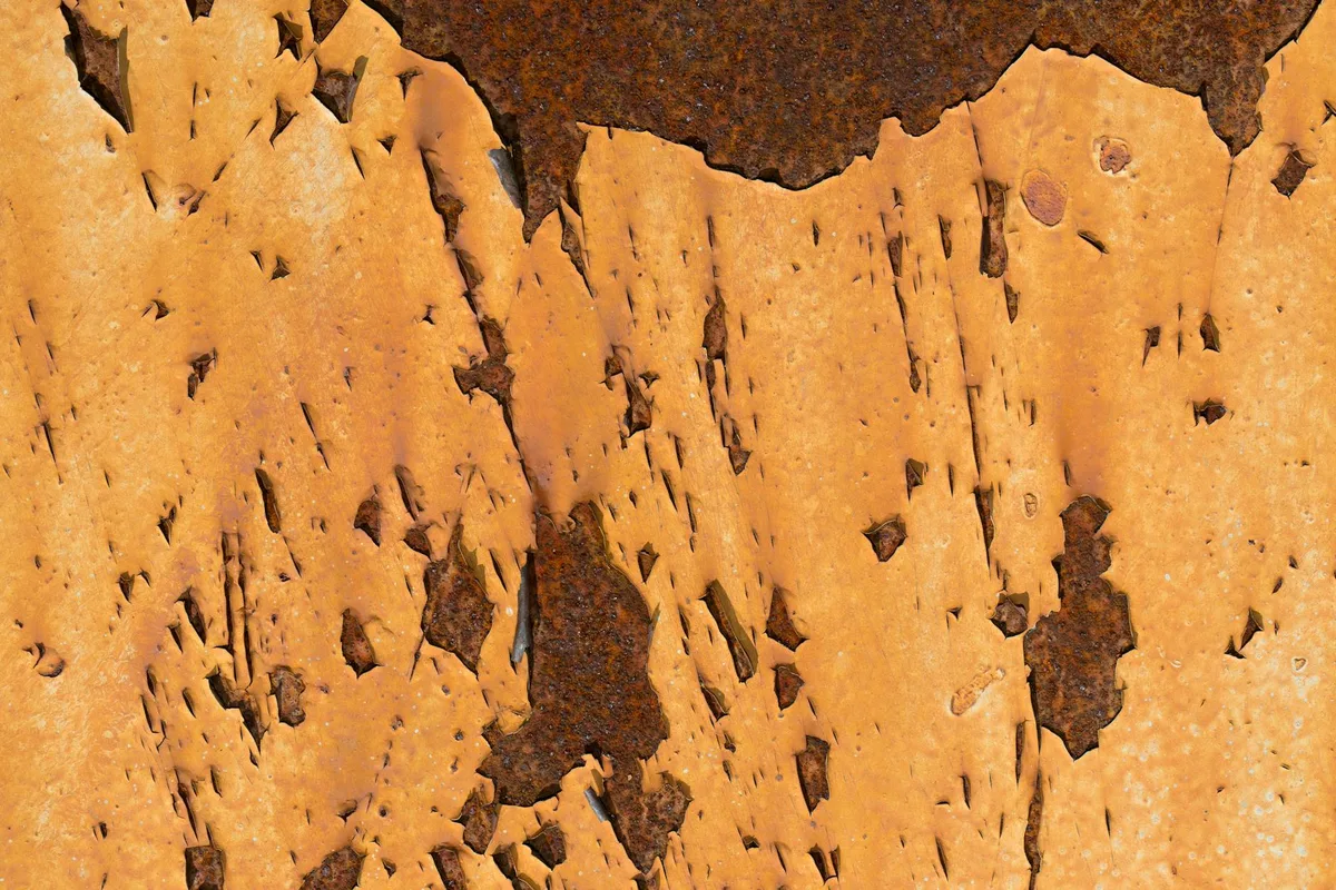 Detailansicht einer rostigen Metalloberfläche mit abblätternder Farbe und Korrosionsmustern