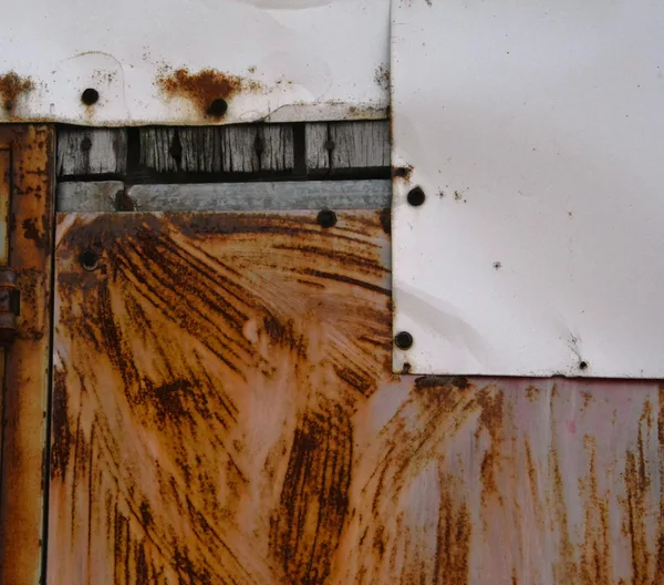 Detailed view of rusty metal with weathered wood and layered textures.