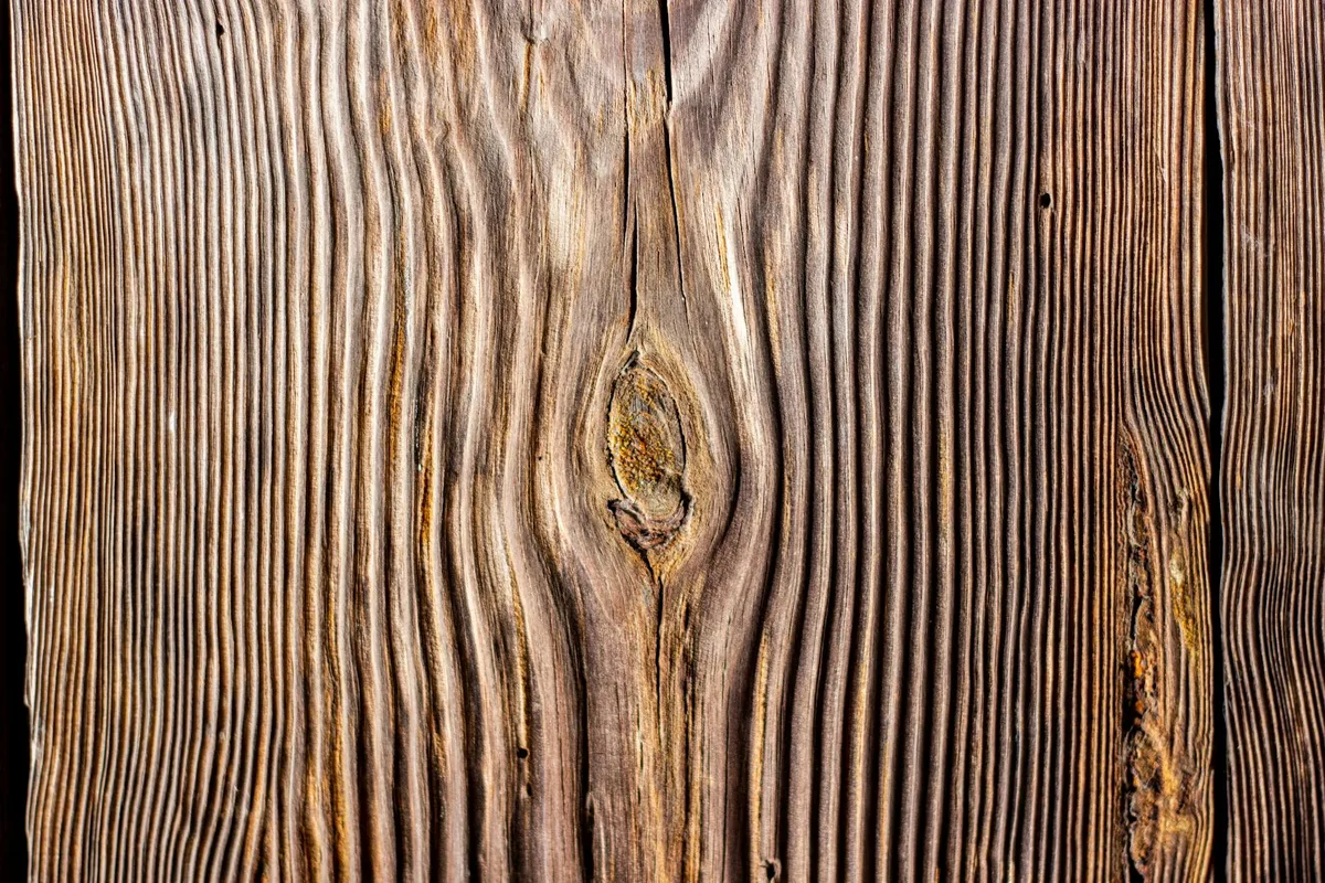 Dettaglio di texture di legno con venature naturali e ricche tonalità marroni.