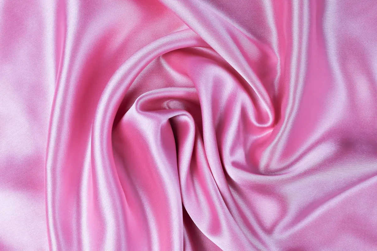 Dettaglio elegante di seta rosa arricciata: texture lussuosa e colore vibrante