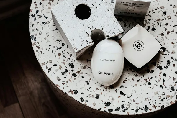 Esposizione minimalista di La Crème Main di Chanel su superficie terrazzo