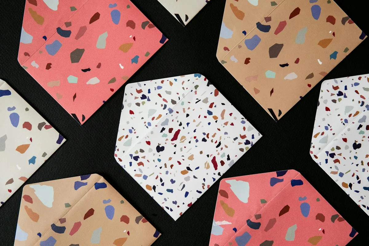 Vista dall'alto di buste con motivo terrazzo vivace su sfondo nero