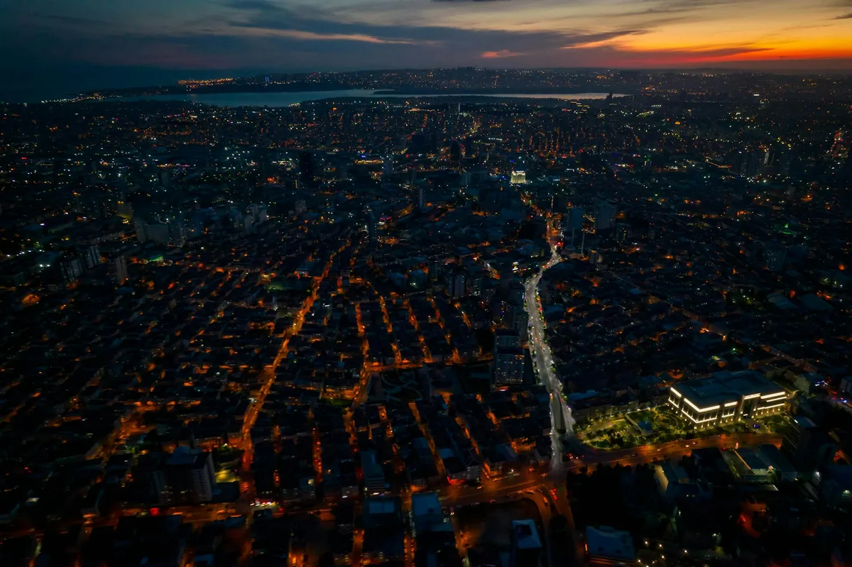Atemberaubende nächtliche Luftaufnahme einer Stadt mit lebhaften urbanen Lichtern in der Dämmerung