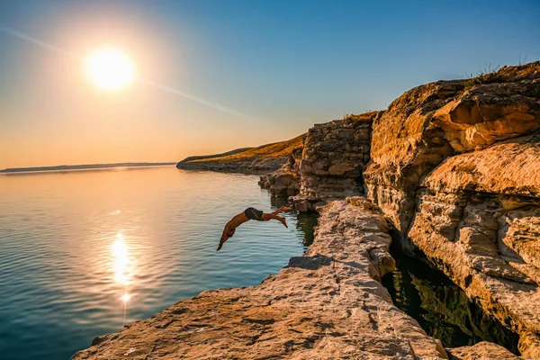 A breathtaking dive from the rocky cliffs of Şanlıurfa, Türkiye, against a stunning sunset backdrop.