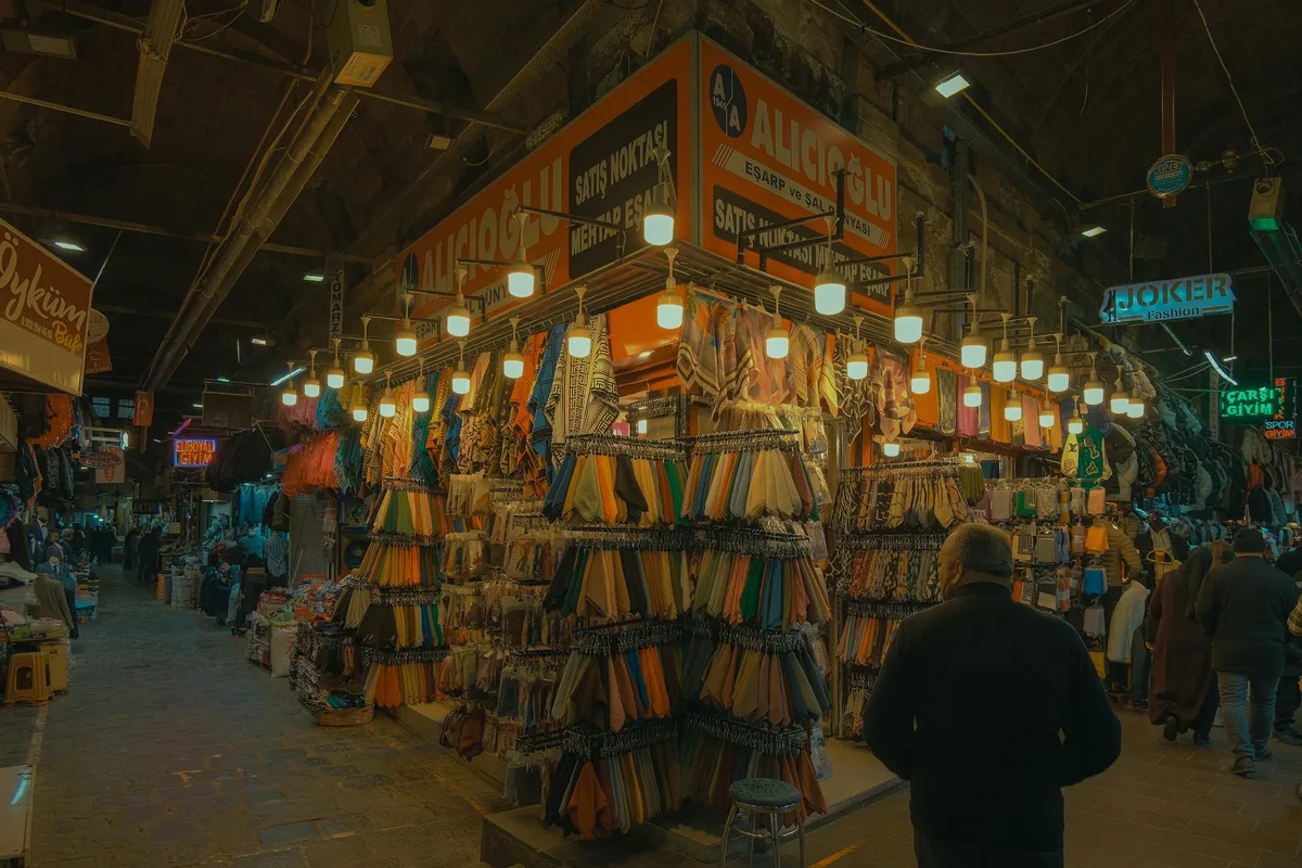 Vista notturna e vivace di un bazar tradizionale a Kayseri, Turchia, con negozi illuminati e acquirenti locali.