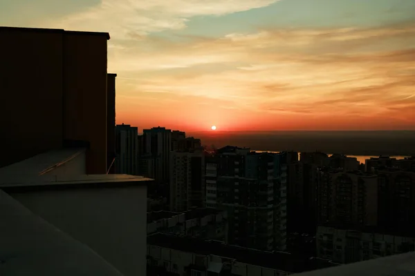 Stadtsilhouette bei lebhaftem Sonnenuntergang mit dramatischem Himmel