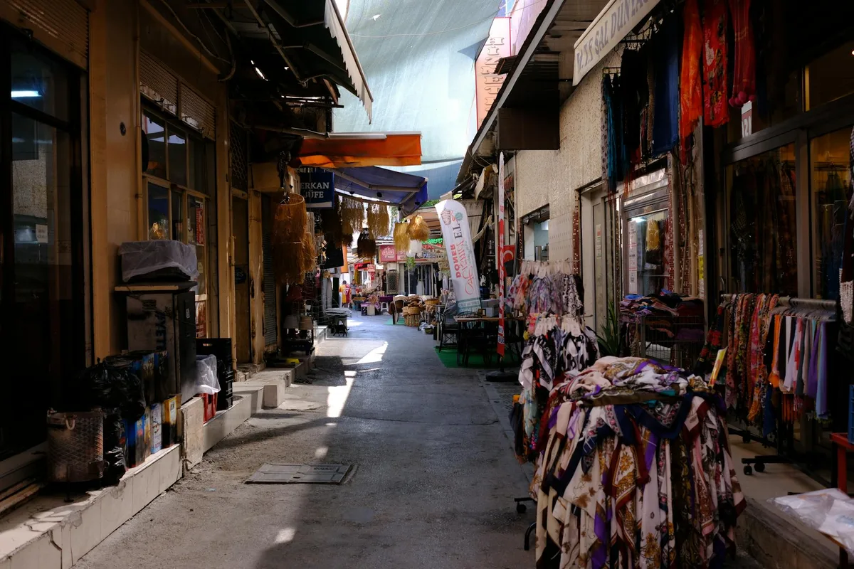 Lebendige enge Marktstraße in Bornova, Izmir: Textilgeschäfte und lokale Kultur