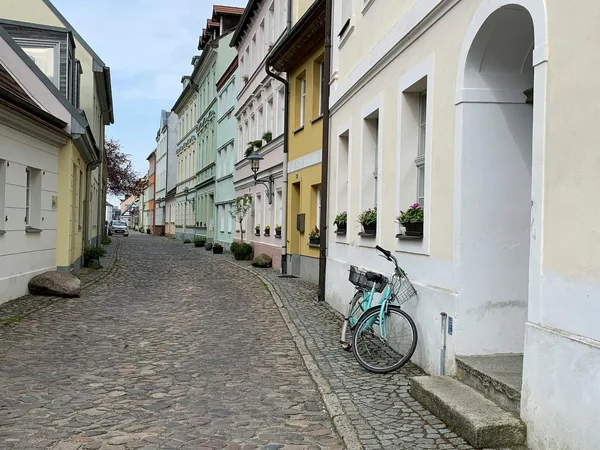 Idyllische Kopfsteinpflasterstraße in Europa mit pastellfarbenen Gebäuden und Fahrrad