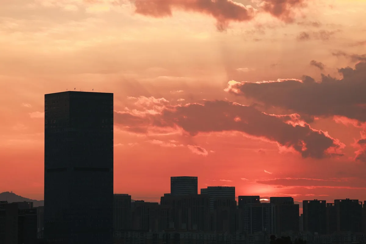 Stadtsilhouette bei Sonnenuntergang mit dramatischen Wolken