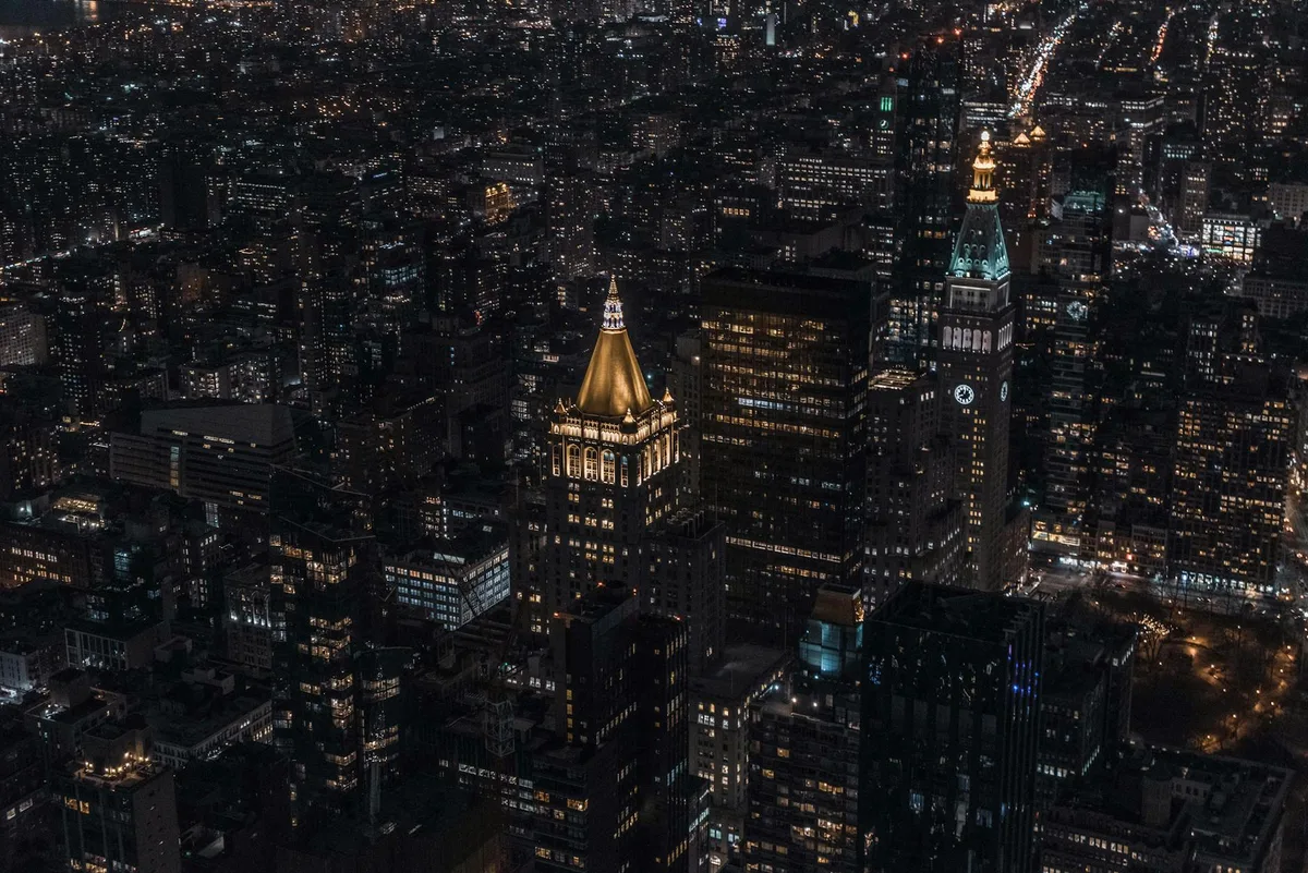 Beeindruckende Luftaufnahme einer lebendigen Stadtlandschaft mit beleuchteten Wolkenkratzern bei Nacht