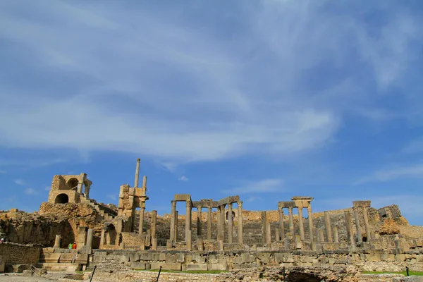 Rovine romane antiche con cielo azzurro e architettura storica