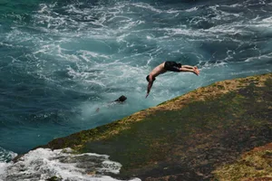 Thrilling dive into the sea from a rugged cliff in Sydney, Australia.
