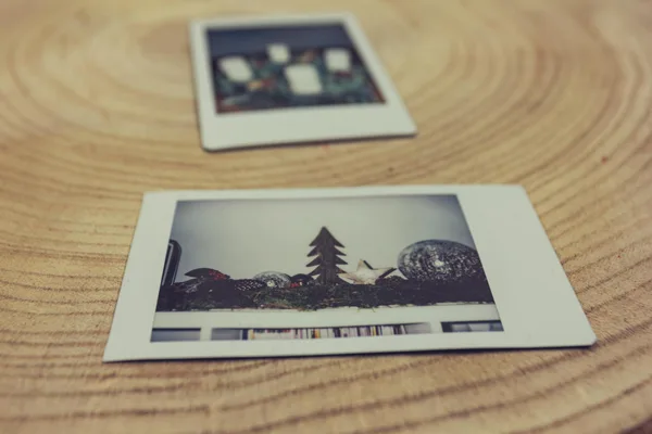 Close-up of Polaroid photos placed on a circular wooden surface, evoking a nostalgic feel.