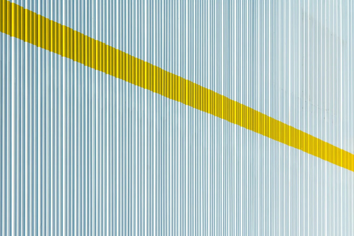Minimalistisches Design mit gelbem Diagonalstreifen auf gestreifter Oberfläche