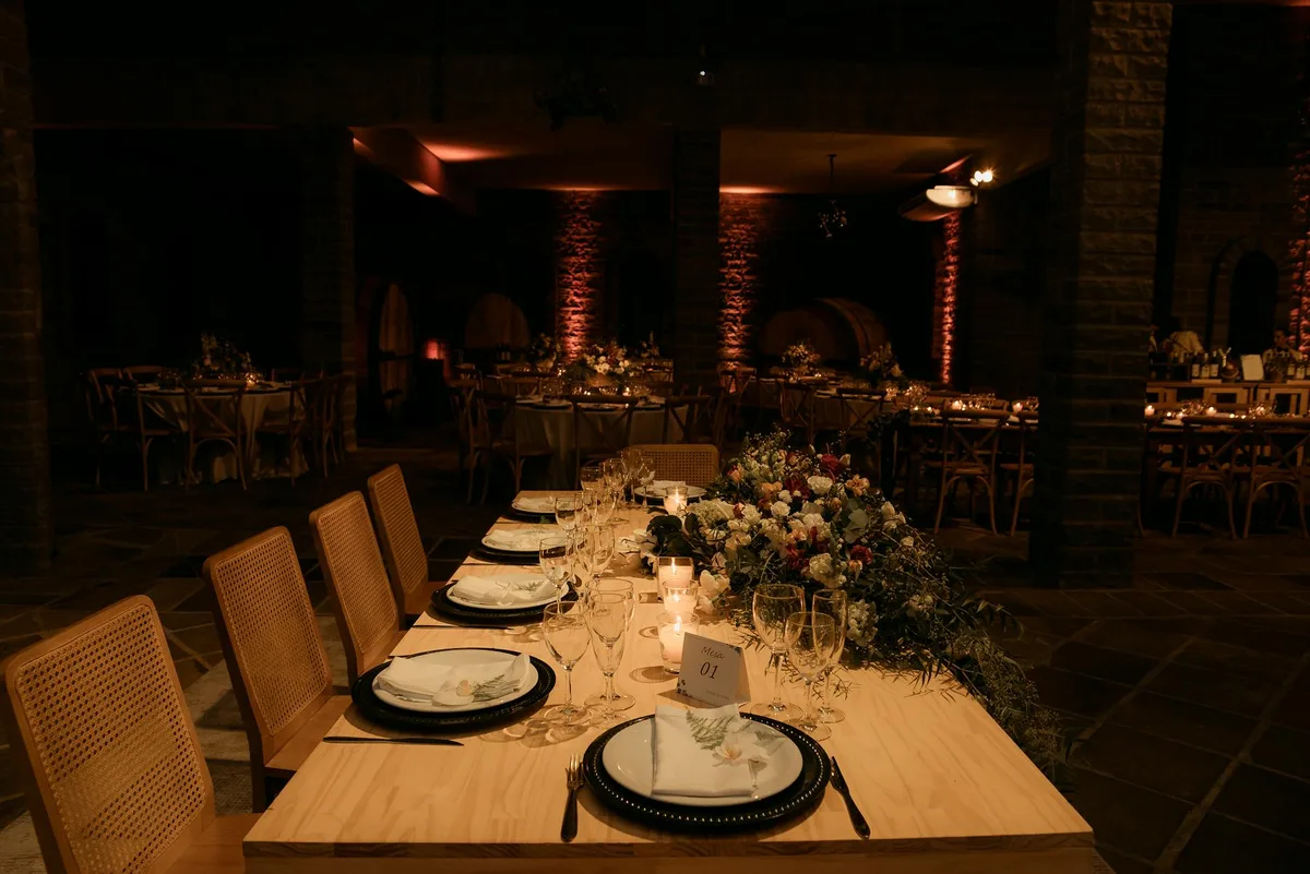 Tavolo ricevimento nuziale con decorazioni floreali e luci soffuse di candele