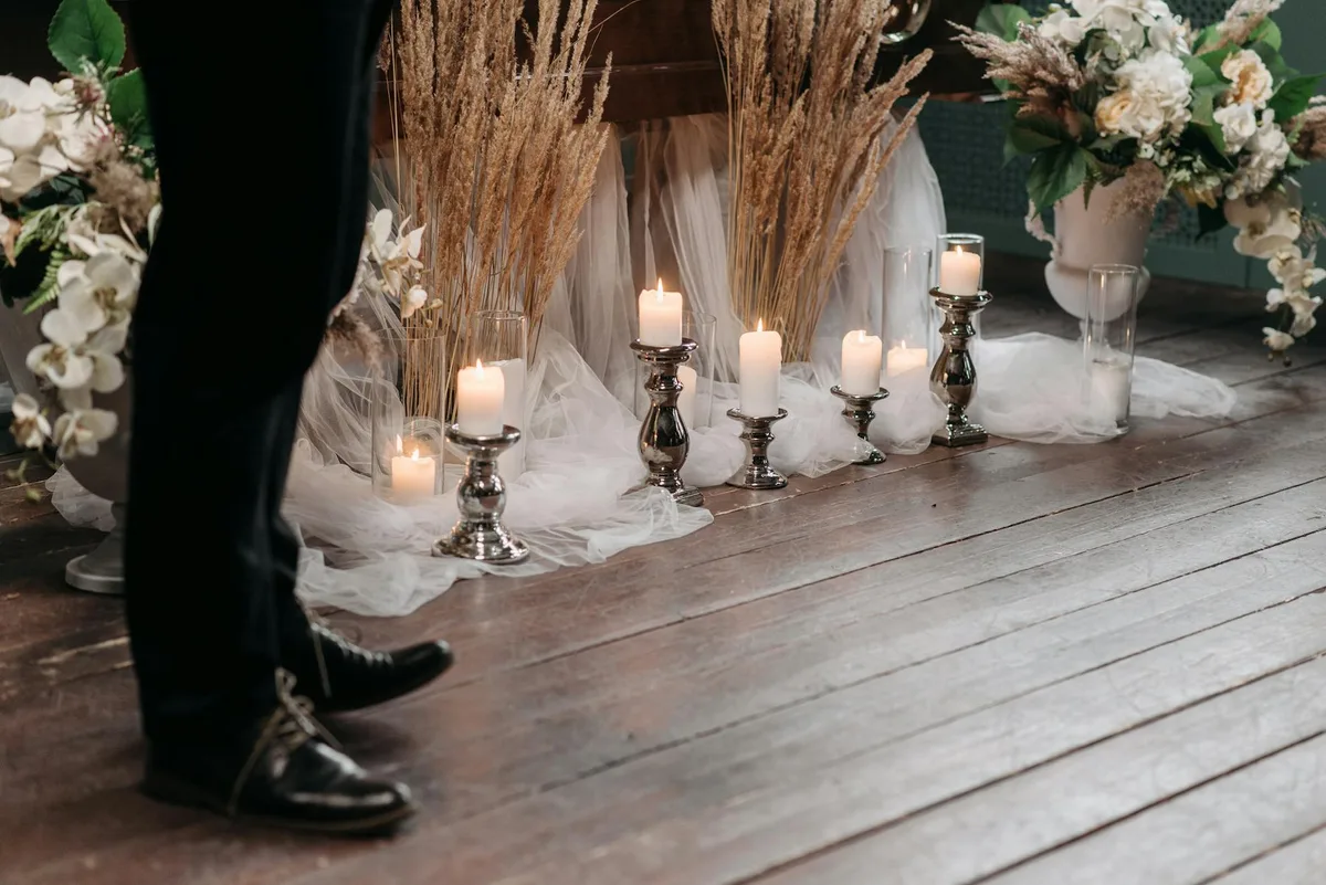 Friedliche Indoor-Hochzeitsszene mit Kerzen und Blumenarrangement