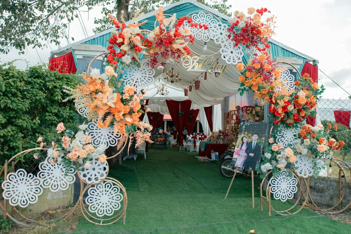 Arco floreale vibrante accoglie gli ospiti a un matrimonio all'aperto festivo