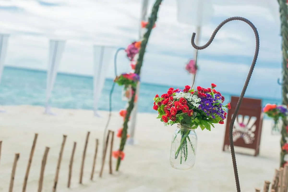 Allestimento matrimonio in spiaggia con fiori colorati e vista oceano
