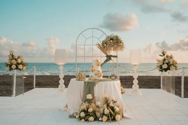 Table de mariage sur la plage avec décor floral et vue sur l'océan