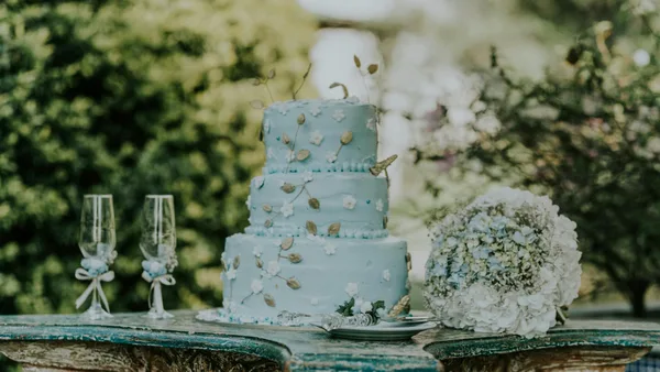 Beautiful blue wedding cake with floral decor and a bouquet, perfect for a romantic setting.