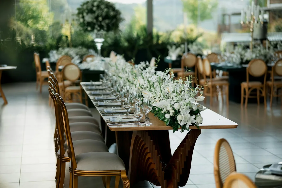 Hochzeitsempfangstisch mit weißen Blumenarrangements und malerischer Aussicht