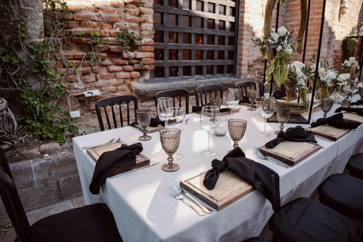Outdoor-Hochzeitstisch mit Blumendekor und elegantem Geschirr für anspruchsvolle Events